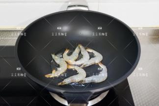 起锅热油，加入大虾煎至变色
