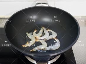 起锅热油，加入大虾煎至变色