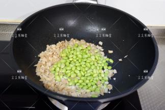 加入毛豆仁干，料酒，生抽翻炒均匀