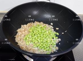加入毛豆仁干，料酒，生抽翻炒均匀