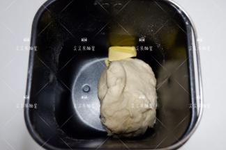 将面团揉至扩展状态，加入黄油揉至完全扩展