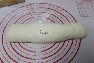 将面团由上至下卷起来，一直卷到头，成为圆柱形的面团。卷面团的时候要贴紧，中间不能有空隙。