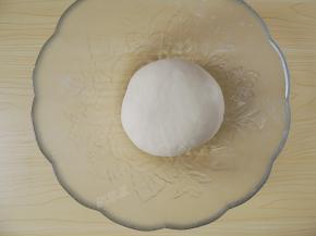 将揉好的面团取出，滚圆后放入容器中，盖上保鲜膜室温发酵。