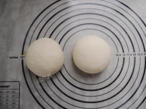 将发酵好的面团倒出，分割成两等分，分别揉圆。