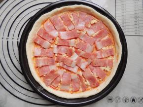 将切好的培根平铺在面饼上。
