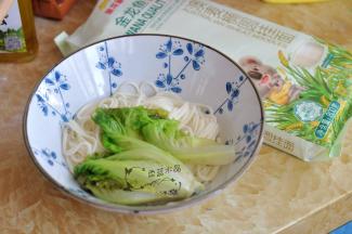 面煮熟后捞出，盛放到碗中，用剩下的水将生菜煮一下断生，也捞出铺到面上。