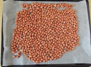 将花生仁清洗干净以后沥干，然后放入烤盘中，尽量平铺，不要堆叠起来。