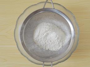 将低筋面粉和糖粉过筛到花生碎中。