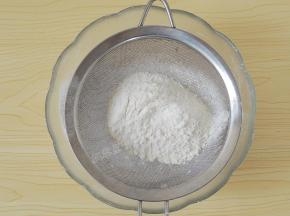 将低筋面粉和糖粉过筛到花生碎中。