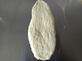 9.取一个面团擀成椭圆，卷起来
