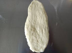 9.取一个面团擀成椭圆，卷起来
