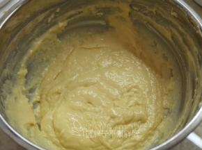 将低筋面粉过筛到蛋黄糊中，用手动打蛋器画“Z”字搅拌均匀。