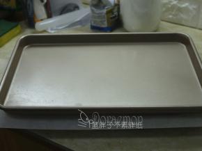 .面团表面盖上一张油纸，在压一个平底烤盘。