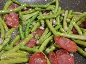 待腊肠油脂炒的差不多，加缸豆迅速翻炒。