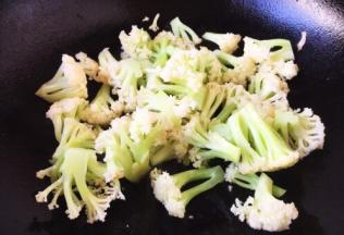 大火置锅，锅微热时，放入少许的油，放入菜花煸炒一下，断生即可。