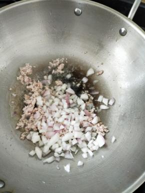 热锅凉油下猪肉和一点点盐，翻炒至猪肉变色。然后加入洋葱，翻炒片刻。