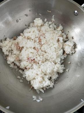 接着倒入米饭，快速把米饭炒散。