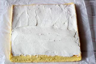 将淡奶油抹在蛋糕的反面（也就是油纸接触的那一面）一边多一边少