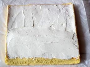 将淡奶油抹在蛋糕的反面（也就是油纸接触的那一面）一边多一边少