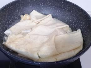 豆腐皮泡软后再焯水:锅中加入水烧开，放入泡好的豆腐皮，煮1分钟即可捞出！