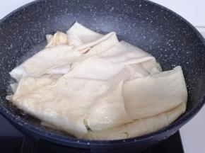 豆腐皮泡软后再焯水:锅中加入水烧开，放入泡好的豆腐皮，煮1分钟即可捞出！