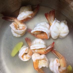 从冰箱把虾仁取出，可以再往烧开水的锅里放些姜，放入虾仁汆水，虾仁微微卷缩变色后捞出备用。