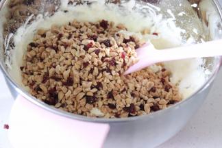 加入保温的花生和蔓越莓，用刮刀辅助，让糖包裹住它们。