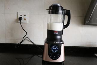 继续倒入水，然后盖上杯盖（事先已将投料盖压紧在杯盖上），再将杯盖顺时针旋转与杯体扣好，接通电源；