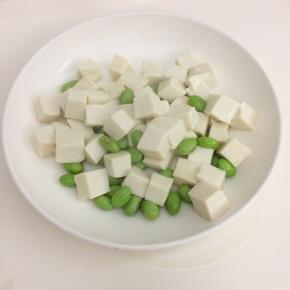 豆腐切成小块，烧一锅开水，把豆腐和毛豆汆水捞起备用。