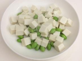 豆腐切成小块，烧一锅开水，把豆腐和毛豆汆水捞起备用。