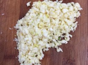 趁着烤箱里烤蘑菇的时候，我们来做蒜蓉。蒜瓣剥皮剁成蒜蓉备用。（蒜蓉不要剁的太早，要不然蒜蓉会变色。）