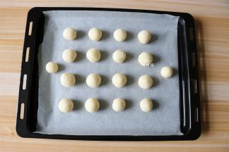 揪一小团揉成圆球形，一一放在铺了油纸的烤盘上;