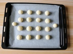 揪一小团揉成圆球形，一一放在铺了油纸的烤盘上;