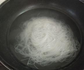 锅里坐水烧开，下泡软的粉丝焯水一分钟，沥水备用