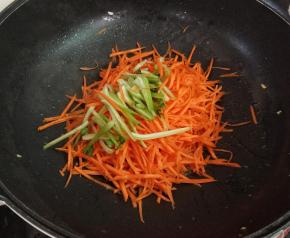 锅中留底油，下胡萝卜丝，青菜根部翻炒均匀