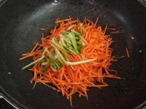 锅中留底油，下胡萝卜丝，青菜根部翻炒均匀