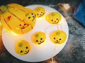 16.晾凉后，把巧克力放裱花袋隔热水融化，在南瓜馒头上画出表情，可可粉加一点点水混合，用毛刷将大南瓜的纹路刷一下，顺便用刀子抠两个洞洞作为表情