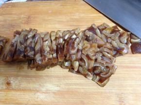 
冻好的肉皮冻取出，将其切成小块再切成片
