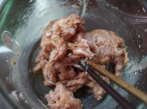 然后加入料酒、生粉、5g鸡粉、5ml美极鲜味汁和香油搅拌均匀