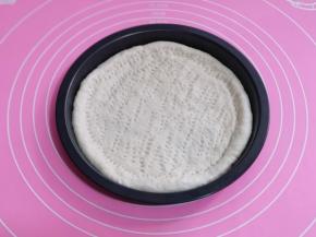 做好的披萨饼胚，挤上番茄酱涂抹均匀。