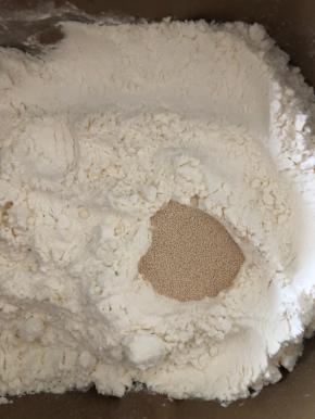 在面粉中挖一个洞，倒入酵母。