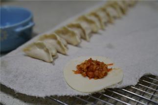 将调好味的馅料包在饺子皮里。饺子的样子随你们自己喜好来包哦。