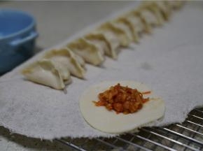 将调好味的馅料包在饺子皮里。饺子的样子随你们自己喜好来包哦。