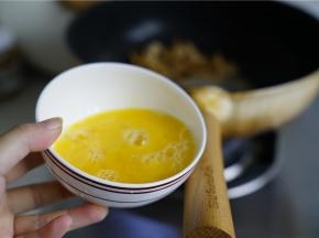 然后将肉末划至锅边，再将鸡蛋打散加至在锅里，煎至凝固。