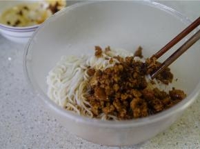 然后将炒好的肉末酱汁一并加至在米粉里面。