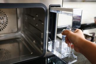 将西屋蒸烤箱的水箱里灌上纯净水，再放回原位，这个水箱的最大容量是1450ml；