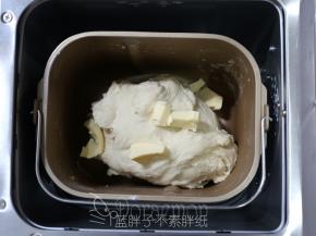 10分钟后，面团能够拉出厚膜，加入软化好的黄油，继续和面程序15分钟。