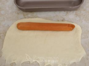 在面团上端放上一根香肠。