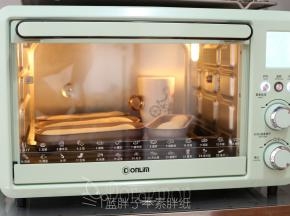 整形好的面团送入烤箱，启动烤箱发酵功能，再放上一杯热水，发酵30分钟。