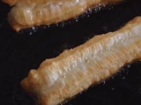 油条炸至金黄色捞出沥干油分